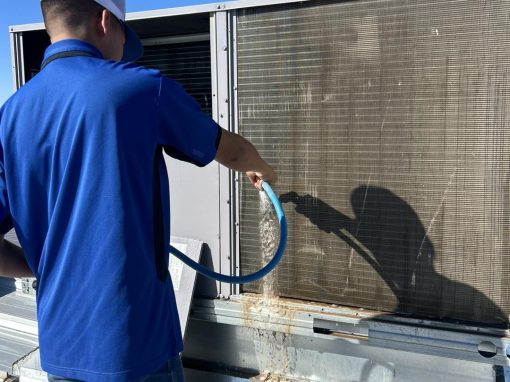 Technician cleaning an AC condenser coil
